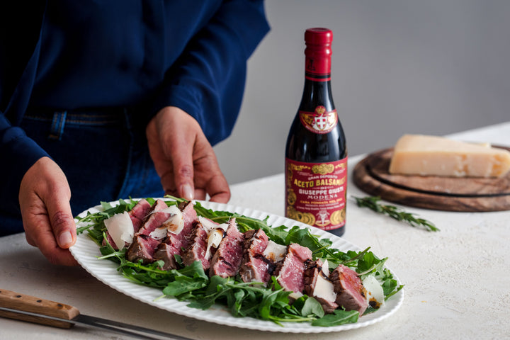 Sliced beef steak on a bed of rocket, with Parmigiano shavings and Balsamico
